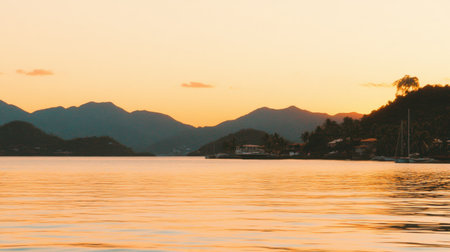 Experience the calm beauty of a sunset reflecting over tranquil water, surrounded by majestic mountains and lush tropical scenery, ideal for relaxation.の素材