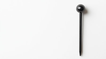 A striking black pin stands alone on a pristine white background, perfect for minimalist designs and creative projects, symbolizing simplicity and elegance.の素材