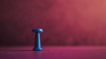A bright blue push pin stands alone against a vibrant background, creating a striking visual ideal for concepts related to organization and office supplies.の素材
