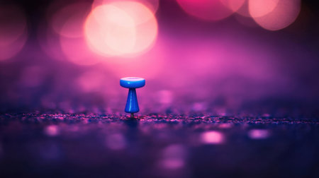 A striking close-up image of a blue push pin sitting on a dark surface, surrounded by a mesmerizing colorful bokeh background, highlighting the pin's details.の素材