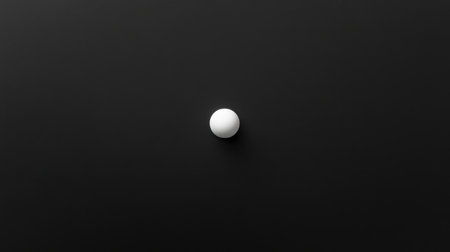 A striking minimalist image showcasing a solitary white sphere centered on a dark background. The smooth texture and soft shadows create a sense of depth and elegance.の素材