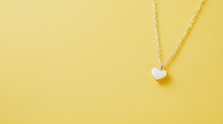 This elegant silver necklace features a simple white heart pendant, set against a vibrant yellow background. Perfect for showcasing style and charm.の素材