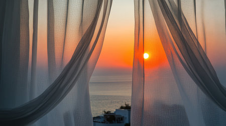 A breathtaking sunset view framed by sheer curtains reveals vibrant hues of orange and pink over a calm ocean. This serene scene evokes feelings of tranquility and relaxation, perfect for capturing the essence of peaceful evenings spent by the sea.の素材