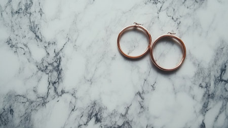 Discover the elegance of rose gold hoop earrings displayed on a smooth marble backdrop. Perfect for showcasing fashion and jewelry styles.の素材