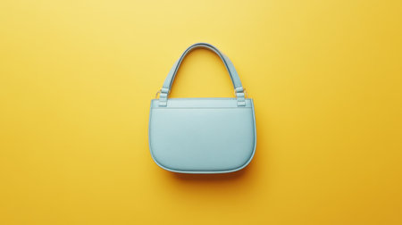 A modern light blue handbag showcased on a vibrant yellow background, perfect for fashion promotions and accessory advertisements. The design is chic and trendy, appealing to a stylish audience.の素材
