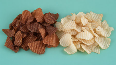 Vibrant photo featuring an arrangement of assorted potato chips displaying distinct textures and colors, ideal for food-related themes and snack concepts.の素材