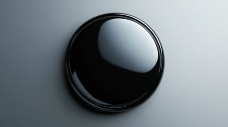 This image features a glossy black round object set against a smooth gray background, perfect for showcasing modern design elements and artistic creativity.の素材
