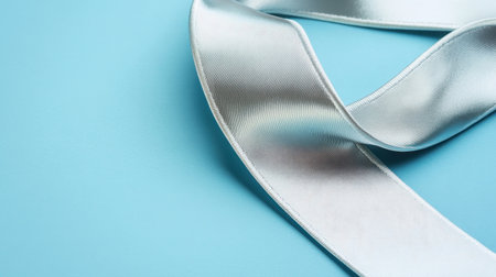 This image features a soft satin ribbon gracefully laying on a light blue background, perfect for various creative design and decoration projects.の素材