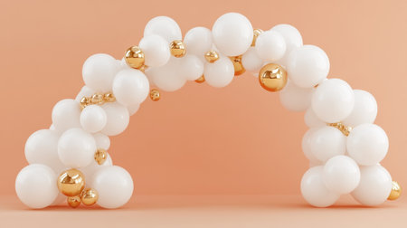 An elegant balloon arch featuring glossy gold and white spheres set against a soft peach background, ideal for festive events, parties, and decorations.の素材
