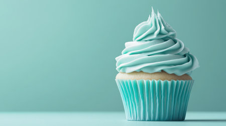 This image features a charming blue cupcake topped with a fluffy swirl of creamy frosting, set against a soft and minimalistic background, evoking a sense of sweetness and delight. Perfect for various dessert-related themes and culinary project needs.の素材