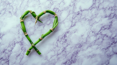 A creative arrangement of green bamboo stems shaped into a heart on a stylish marble surface, symbolizing love and harmony in nature.の素材