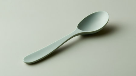 This image features a minimalist gray spoon set against a neutral background, offering a sleek design element perfect for culinary-themed projects.の素材