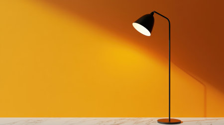 A sleek black floor lamp stands gracefully against a vibrant orange wall, casting a warm glow on a marble surface, creating a serene atmosphere.の素材