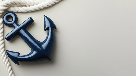 A striking blue anchor resting against a smooth neutral background, accompanied by a twisted rope, ideal for maritime-themed designs or decor.の素材