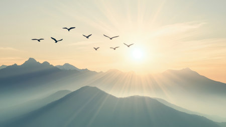 A breathtaking sunset view showcases a mountain range, with silhouetted birds soaring gracefully across the sky during the golden hour light.の素材