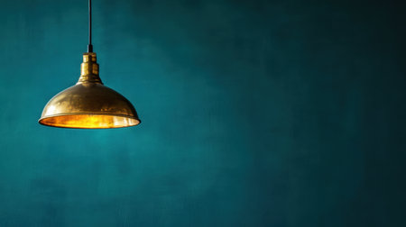 This image features an elegant brass pendant light hanging against a soft blue background, perfect for showcasing modern interior design elements and atmospheric lighting ideas.の素材