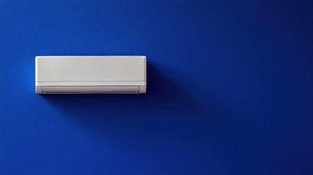 A sleek white air conditioning unit positioned on a vibrant blue wall provides a stylish and efficient cooling solution for modern interiors.の素材