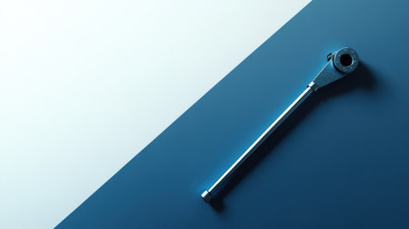 A striking image of a metal tool resting on a two-tone surface, highlighting its design and function in industrial and maintenance settings.の素材