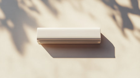 A minimalist white air conditioning unit set against a soft shadow background. This sleek design element enhances modern interiors in both homes and offices.の素材