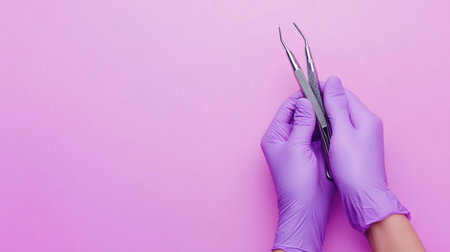 A striking image featuring a pair of hands clad in purple gloves skillfully holding precision dental tools against a soft pink background, emphasizing cleanliness and professionalism.の素材