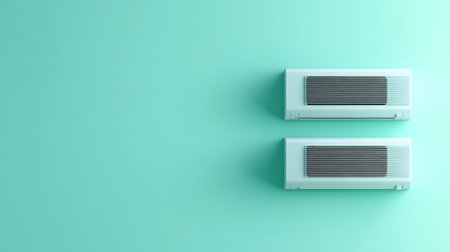 Two modern air conditioners are seamlessly mounted on a stylish mint green wall, showcasing contemporary design and effective cooling technology for a comfortable indoor environment.の素材