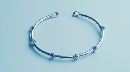 A stunning silver necklace adorned with sparkling blue gemstones rests gracefully on a soft blue background, capturing elegance and style.の素材