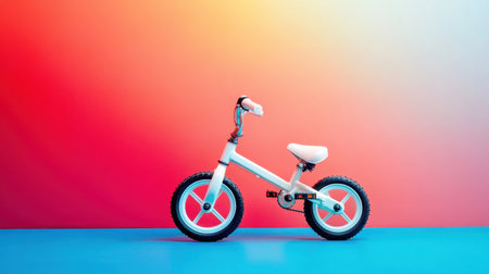 A stylish balance bike stands alone against a vivid gradient backdrop, perfect for promoting outdoor fun and childhood adventures. Ideal for playful imagery.の素材
