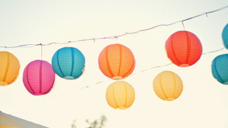 A stunning display of colorful paper lanterns hanging gracefully outdoors in soft evening light, perfect for enhancing festive celebrations and events.の素材