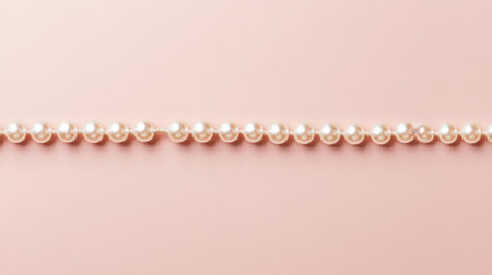 A stunning arrangement of pearls on a soft pink background, perfect for highlighting fashion, elegance, and sophistication in visual storytelling.の素材