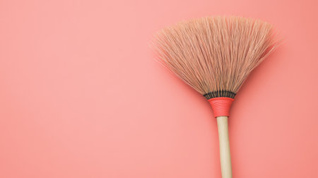 This image showcases a stylish broom with soft bristles, set against a vibrant pink background. Perfect for promoting cleaning tools in modern settings.の素材