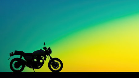 A striking silhouette of a vintage motorcycle set against a stunning sunset sky with vibrant yellow and blue gradients, evoking a sense of adventure and freedom.の素材