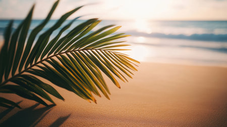 A vibrant palm leaf rests on a sandy beach, capturing the essence of tropical paradise. Gentle ocean waves caress the shore under a warm sunset glow.の素材
