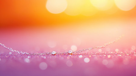 A stunning close-up image of a delicate silver chain necklace featuring sparkling gems, set against a vibrant bokeh background of pink and orange, showcasing elegance.の素材