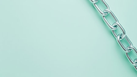 A detailed close-up of a shiny silver metal chain lying on a soft mint background, ideal for minimalistic designs and conceptual projects.の素材