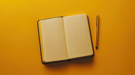 An open notebook with empty pages lies next to a pen, set against a vibrant yellow background. Ideal for writing, planning, and inspiring creativity.の素材
