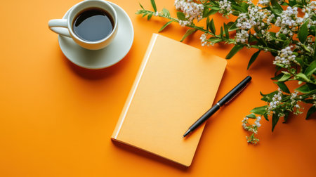 A vibrant flat lay scene featuring a cup of coffee, a stylish orange notebook, and fresh flowers, creating an inspiring workspace atmosphere.の素材