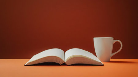 A cozy scene featuring an open book and a white coffee mug on a warm orange surface. This setup evokes feelings of relaxation and inspiration, perfect for leisurely reading or study breaks.の素材