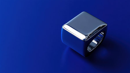 A shiny metal ring rests on a vibrant blue background, emphasizing its sleek design and craftsmanship. This modern accessory is perfect for jewelry enthusiasts.の素材