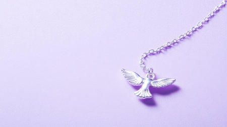 This image features a delicate silver bird pendant necklace resting on a soft purple background, ideal for jewelry enthusiasts and fashion lovers.の素材