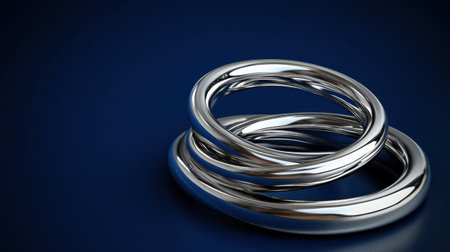 This captivating image features shiny silver rings intertwined beautifully against a dark background, highlighting elegance and luxury. The metallic reflection adds depth.の素材