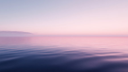 This serene image captures the tranquil surface of the ocean at dawn, featuring soft pastel colors and a peaceful horizon that invites relaxation and meditation.の素材