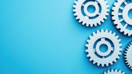 This image features an arrangement of white gears set against a bright blue background, symbolizing innovation and mechanical engineering concepts. Ideal for various industrial and technological applications.の素材