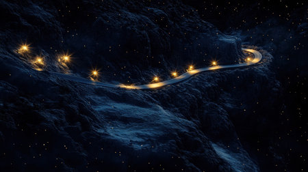 A winding road illuminated by twinkling lights, set against a dark mountainous landscape filled with stars, creates a serene, dreamlike atmosphere for adventurous travelers.の素材