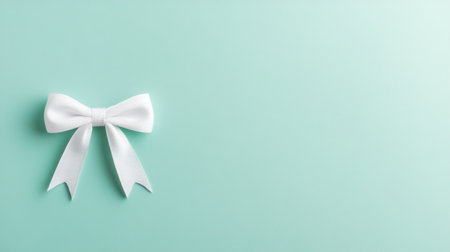 This image features a pristine white bow placed elegantly against a soft mint background, ideal for gift wrapping, decoration, or artistic projects.の素材