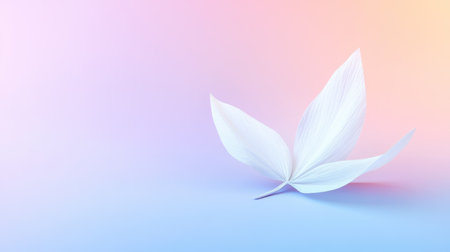A delicate white leaf rests gracefully on a soft pastel gradient background featuring shades of pink and blue, evoking calmness and tranquility.の素材