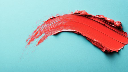 A striking image of a vibrant red paint stroke on a soft blue background, ideal for creative projects, artistic endeavors, and modern design inspirations.の素材