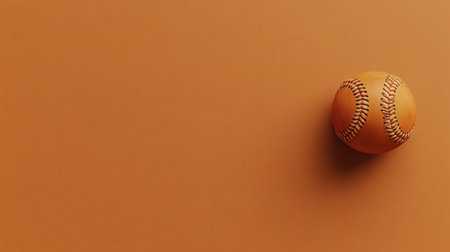 This image features a vintage-style baseball resting against a warm orange background. The play of light and shadow adds depth, ideal for sports-related visuals.の素材