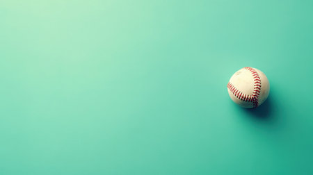 A solitary baseball sits against a smooth turquoise backdrop, evoking themes of sport, recreation, and vibrant playfulness, ideal for various creative projects.の素材