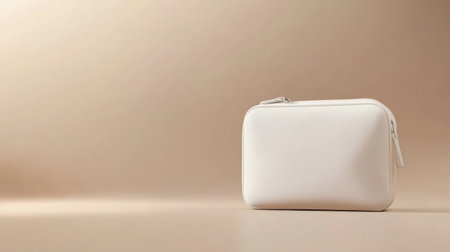 A sleek and elegant white travel case sits against a smooth beige background, perfect for showcasing minimalist storage solutions and organization ideas.の素材