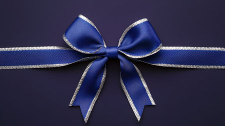 A beautifully crafted blue satin ribbon bow with silver trim, perfect for enhancing gift presentations or adding a stylish touch to decorations.の素材